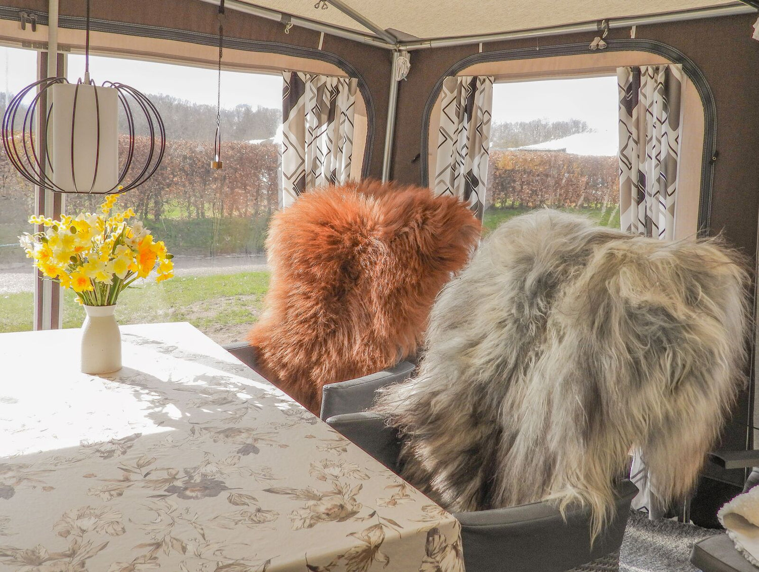 Zwei Campingstühle mit Schaffell in einem Vorzelt