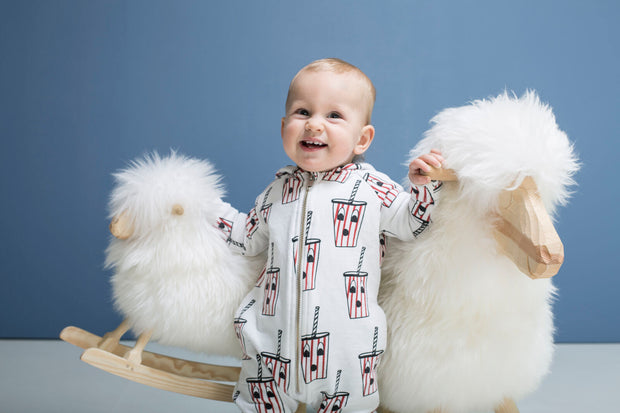 Kleinkind spielt mit zwei weissen Schaukelschafen