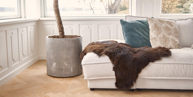 Sofa mit braunem Lammfell und Kissen